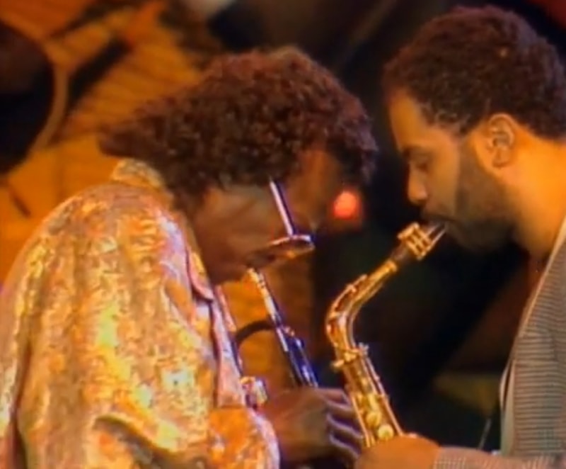 Miles Davis plays the trumpet face to face with saxophonist Kenny Garrett.