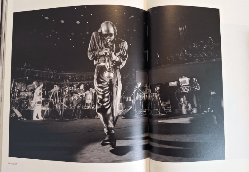 A dramatic photograph of Miles Davis on stage in Germany.